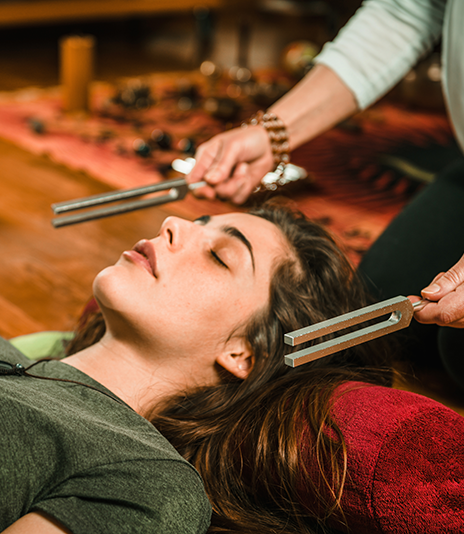 A person listening while a tuning fork is used nearby