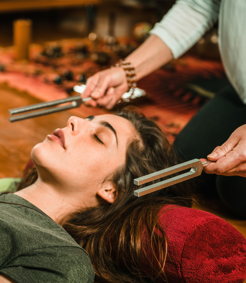 A image of a lady receiving sound healing therapy.